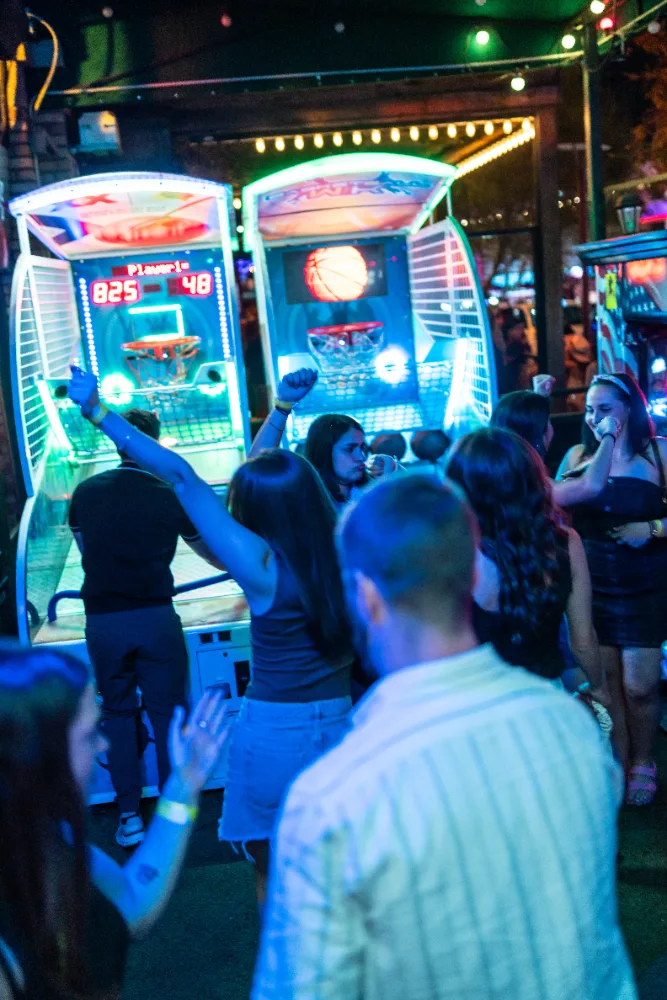 Guests playing arcade basketball on the patio at Mother Tucker's Tavern