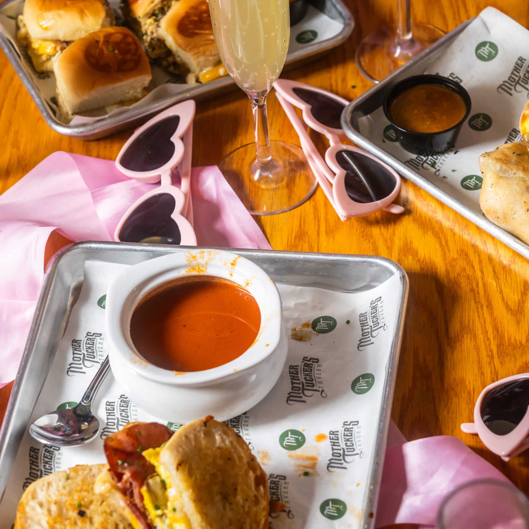Brunch spread with sliders, dipping sauces, and mimosas at Mother Tuckers Tavern